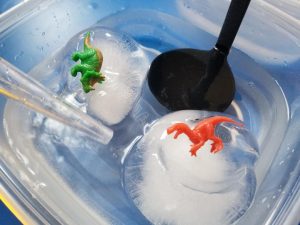 Ice Balloons with Dinosaurs hidden inside. A fun science experiment for kids.